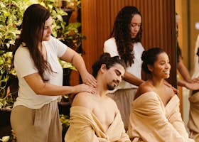 Men and women enjoying relaxing massages at a spa, surrounded by greenery, promoting wellness and relaxation.